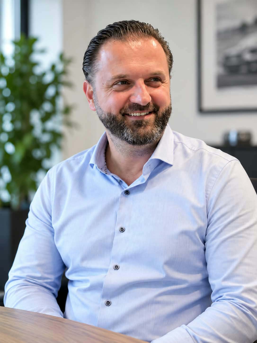 Medi Gajtani, salgsrådgiver hos CC Biler, smilende på kontoret